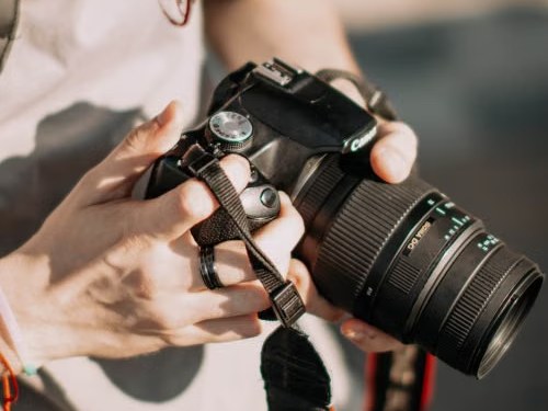 Mãos a ajustar uma máquina fotográfica